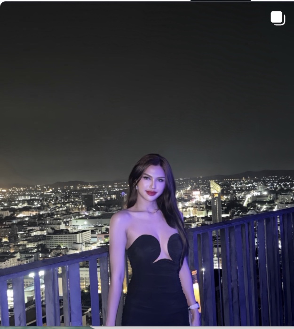 Tali in a black evening look overlooking the city